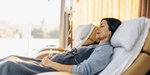 Woman receiving IV vitamin therapy in a comfortable recliner at a wellness clinic