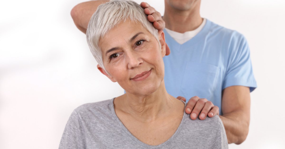 Older woman receiving chiropractic neck adjustment from a male practitioner, highlighting safe chiropractic care for seniors.