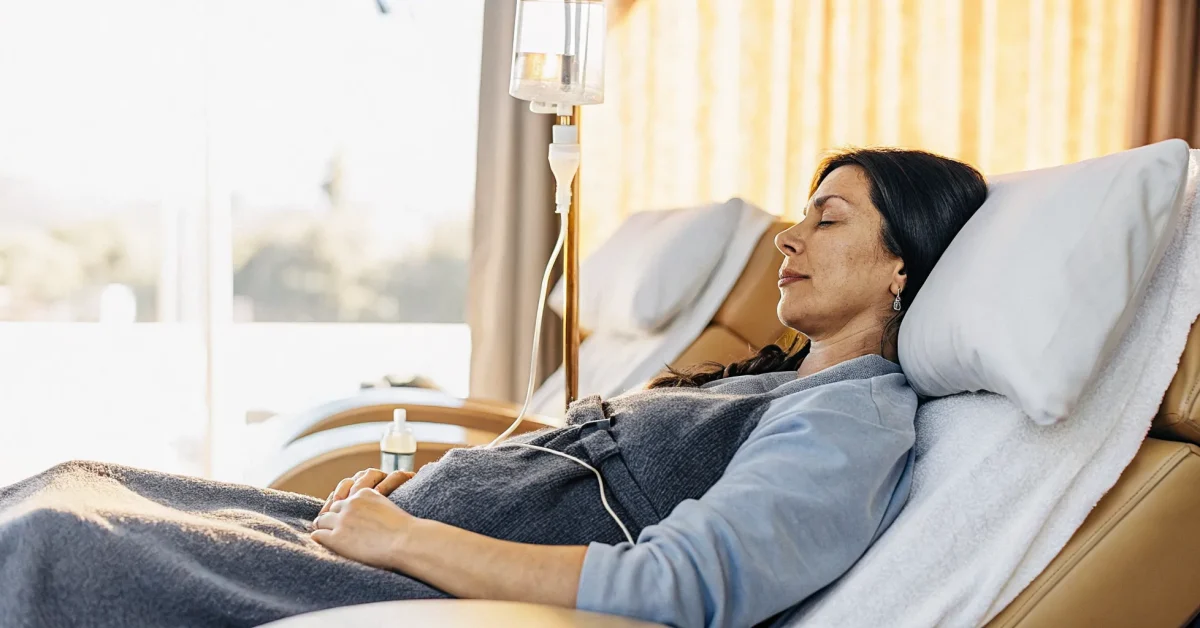 Woman receiving IV vitamin therapy in a comfortable recliner at a wellness clinic